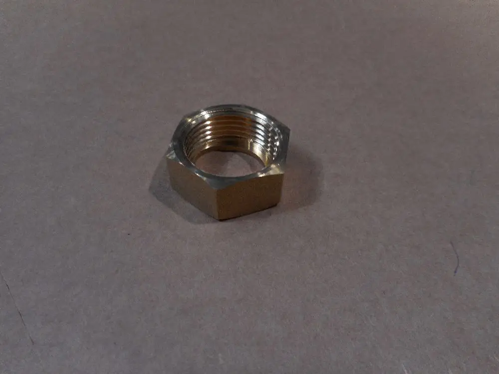 Mutter aus Metall, sechseckig mit Innengewinde, auf braunem Untergrund. Erzeugt von Remeha für Rohrverbindungen oder Befestigungen.